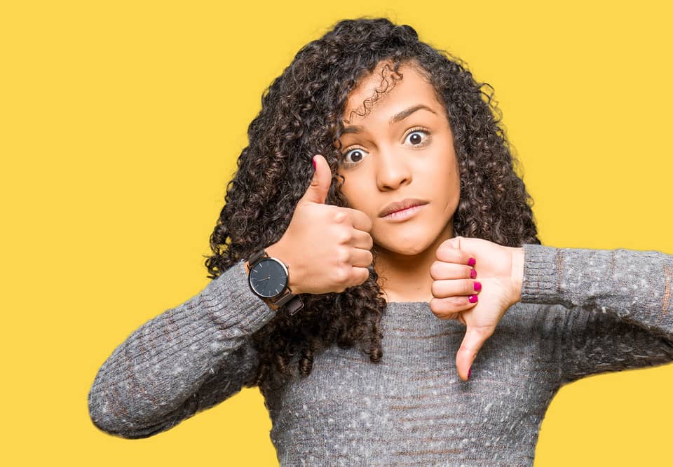 A woman showing thumbs up and thumbs down